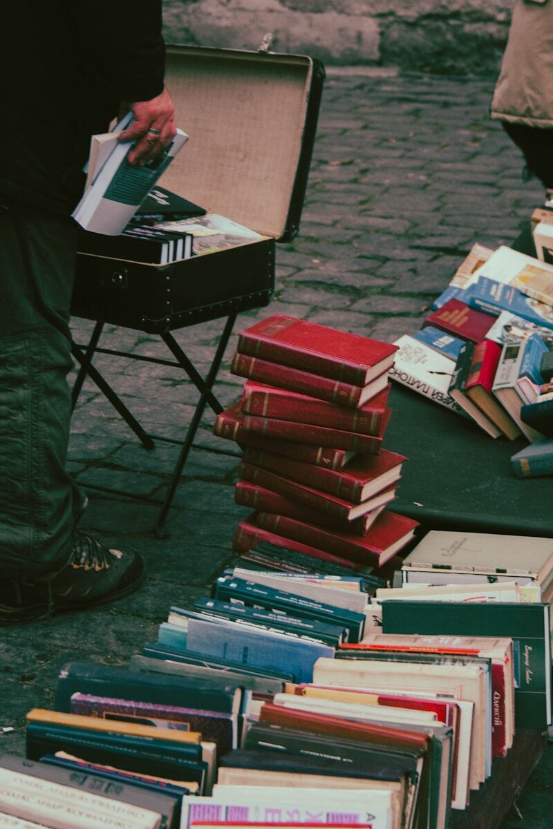 a man standing next to a pile of books